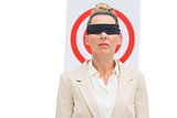 Businesswoman blindfolded and target behind