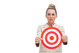 Frowning businesswoman holding target