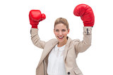Cheering businesswoman wearing boxing gloves