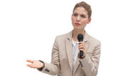 Frowning businesswoman holding microphone
