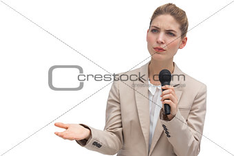 Frowning businesswoman holding microphone