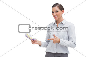 Happy businesswoman pointing to money in her hand