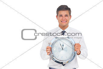 Concerned businessman holding clock