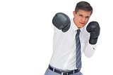 Businessman punching with black boxing gloves