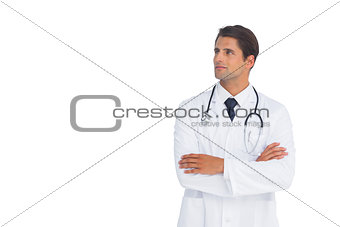 Smliing doctor with arms crossed looking up