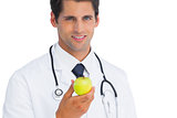 Doctor holding an apple and smiling