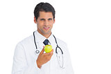 Doctor holding an apple and smiling at camera