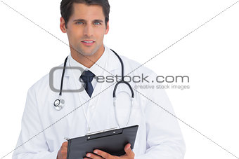 Doctor writing on his clipboard and looking at camera