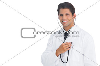 Happy doctor holding up stethoscope to his chest