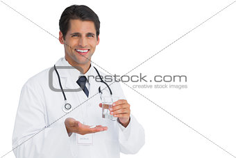 Cheerful doctor holding tablets and water