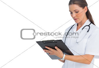 Serious nurse writing on clipboard