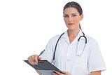 Nurse holding clipboard and looking at camera