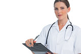 Unsmiling nurse holding clipboard and looking at camera