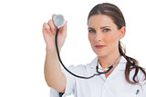 Serious nurse holding up stethoscope