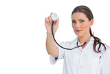 Stern nurse holding up stethoscope