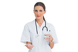 Smiling nurse holding medicine and glass of water