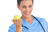 Happy surgeon holding an apple and smiling