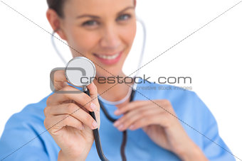 Smiling surgeon holding up stethoscope