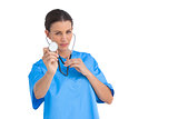 Serious surgeon holding up stethoscope
