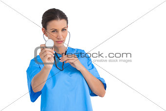 Serious surgeon holding up stethoscope