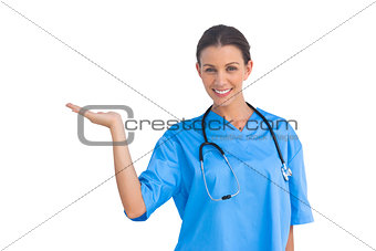Surgeon holding up hand in presentation and smiling at camera