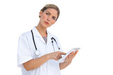 Serious nurse pointing something on tablet pc