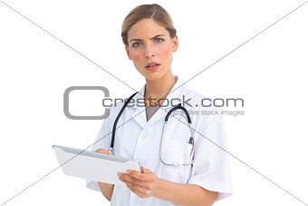 Puzzled nurse with tablet pc