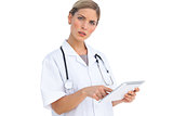 Annoyed nurse using tablet pc
