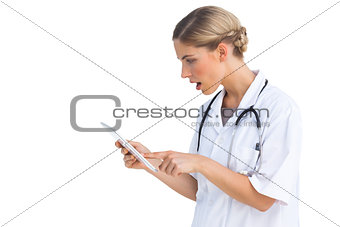 Side view of surprised nurse with tablet pc