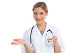Smiling nurse holding drugs and water glass