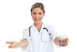Smiling nurse giving drugs and water glass