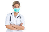 Nurse wearing surgical mask with arms crossed