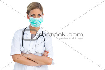 Nurse wearing surgical mask with arms crossed