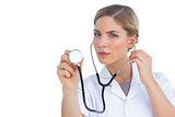 Serious nurse listening with stethoscope
