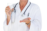 Doctor holding out pills and water glass