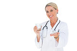 Happy doctor holding out pills and water glass