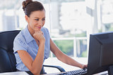 Businesswoman working on her computer and smiling