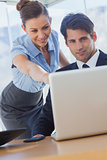 Smiling businesswoman pointing at the laptop