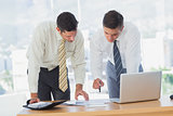 Businessmen working together leaning on desk