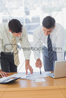 Serious businessmen working together leaning on the desk