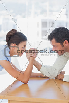 Competitive business people arm wrestling