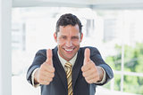 Smiling businessman with thumbs up
