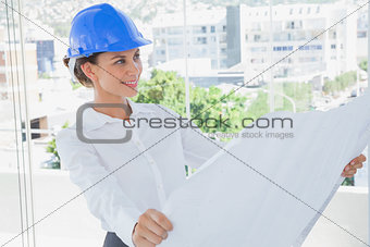 Smiling architect rolling out a blueprint