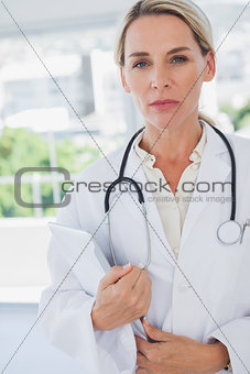Serious blonde doctor standing