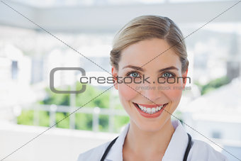 Beautiful smiling doctor standing in her office