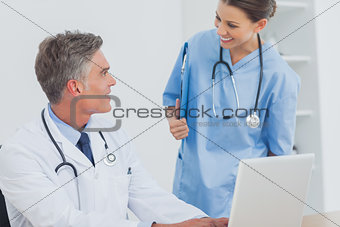 Doctor with a clipboard talking to a colleague