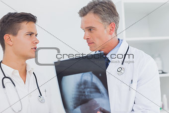Two doctors holding and analysing an xray