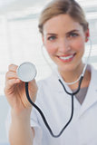 Smiling nurse showing her stethoscope