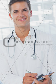Handsome doctor holding pen