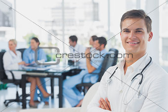 Smiling doctor with arms folded standing